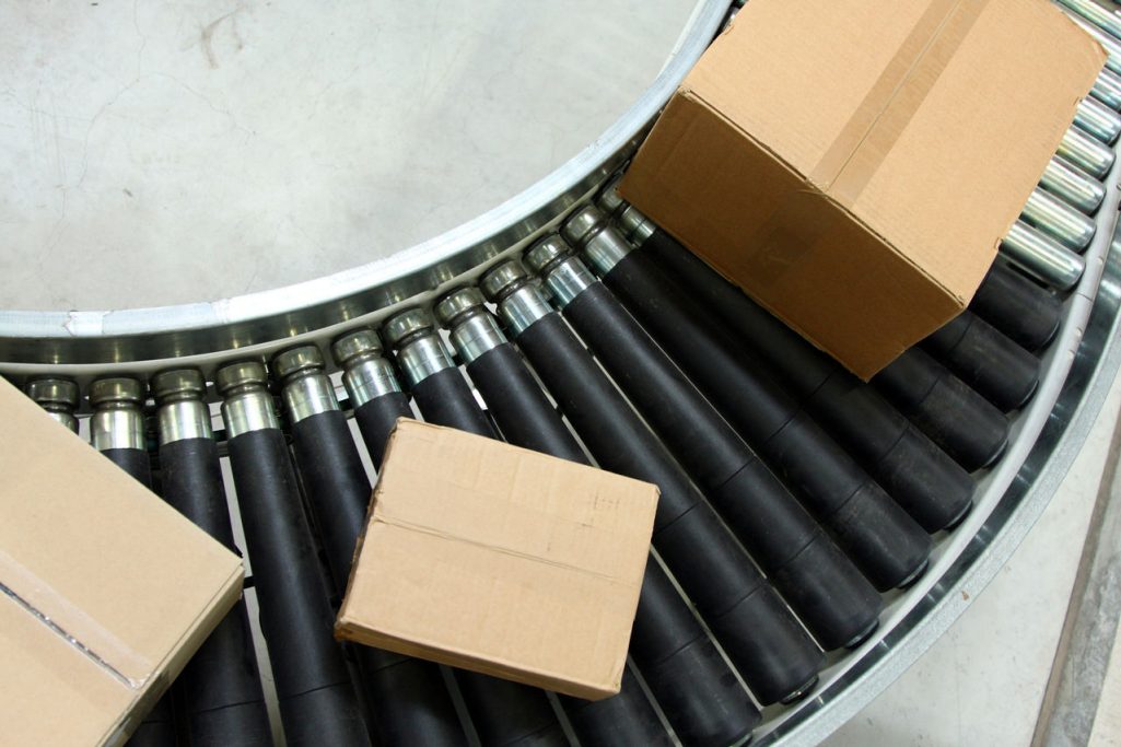Cartons roll across a curved section of a warehouse  conveyor system